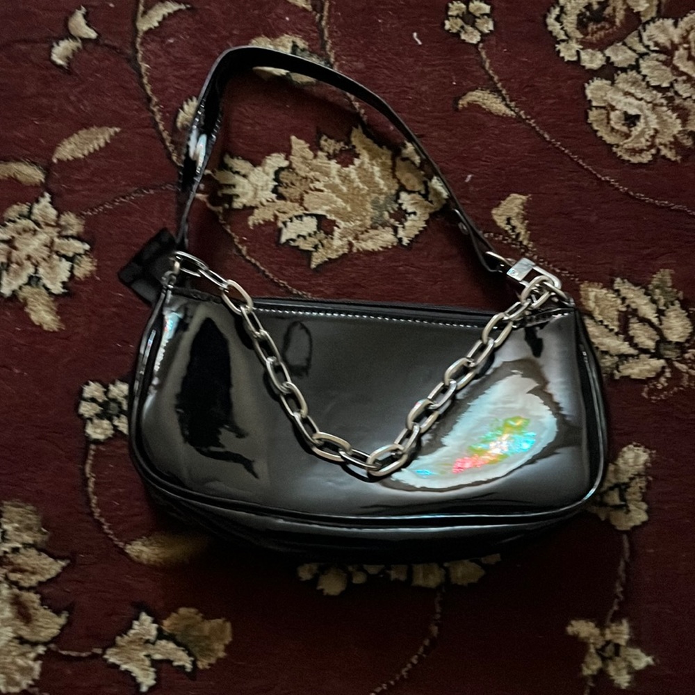 Really cute arm bag in the color black with a silver chain.